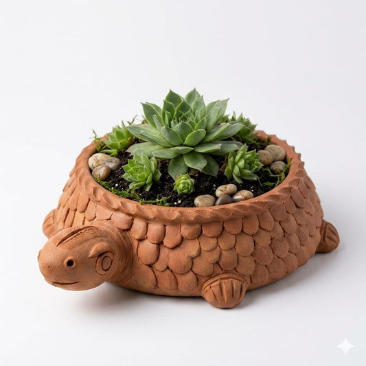 A terracotta turtle-shaped planter with a textured, scale-like shell, filled with green succulents and small decorative stones, set against a plain white background.